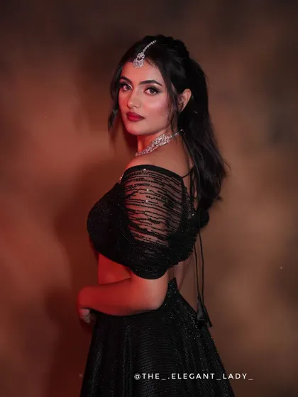 A stylish shot from the back, showing the elegant drape of the black shimmer lehenga and the model's confident pose.