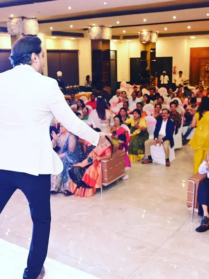 From the stage to the audience, I make sure to engage with everyone. Here I am getting the guests seated in the front rows involved in the fun.