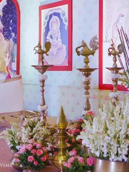 Traditional brass elements like the Nandi statue and tall diyas (lamps) are central to our South Indian decor. They are surrounded by fresh flowers, adding a touch of divinity and cultural richness.