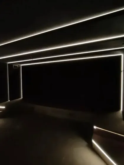 The architectural lighting in this theater is a key design element, with LED strips outlining the room's perimeter for a futuristic feel.