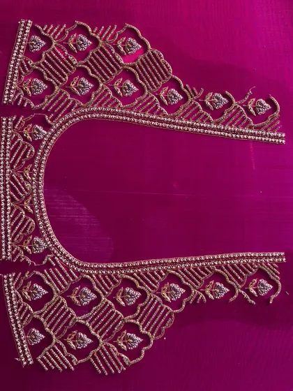 The neckline and back piece of a custom blouse, laid out to show the complete, intricate pattern before it is stitched into a final garment.
