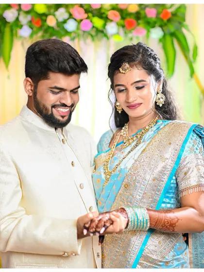 The groom smiles as he places the ring on the bride's finger. This photo captures the peak of the ring ceremony, filled with joy and anticipation.