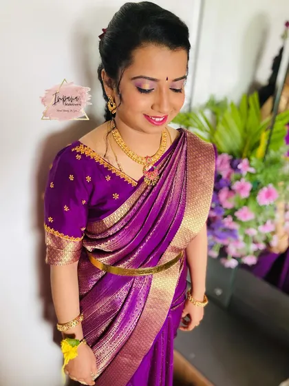 A beautiful client ready for her housewarming ceremony. The makeup is soft and traditional, paired with an elegant purple saree.