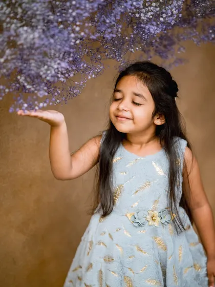 A simple and beautiful studio portrait with a cascade of purple flowers. Sometimes a single, elegant prop is all you need.