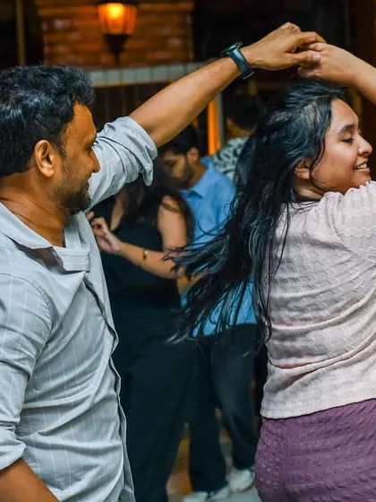 A dynamic turn with hair flying, capturing the energy of a great Salsa song. The floor is always alive with movement.