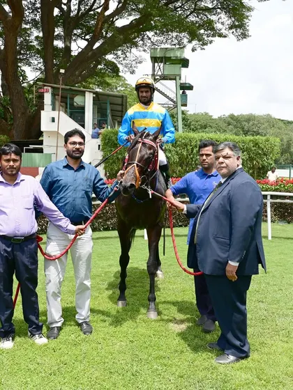 Tolkien stands in the winner's enclosure after securing The Champion Trainer Cup, alongside jockey S. Antony Raj and the owners.