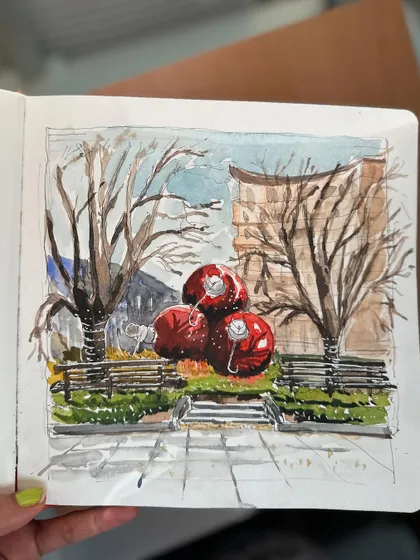 A close-up of my festive watercolour sketch, capturing the giant red Christmas ornaments and the bare winter trees.