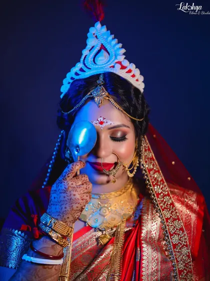 Another creative shot of the Bengali bride, using a prop and blue lighting. Her closed eyes and gentle smile give the portrait a dreamy and artistic feel.