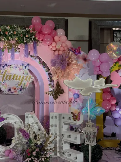 The intricate details of the stage decor include tassel garlands, floral arrangements, and layered arches that create depth and visual interest.
