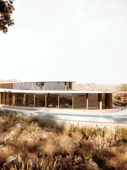The curved form of Amar Villa nestled within the wild, natural vegetation of the site, demonstrating a harmonious relationship between the built form and its environment.