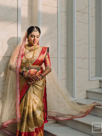 A full-length bridal portrait, with the bride's sheer veil creating a beautiful, flowing silhouette in the sunlight.