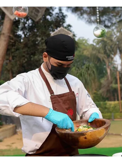 A chef mixing a custom salad for a guest, part of our interactive salad bar concept.