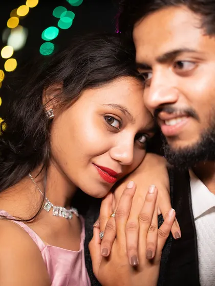 A cozy nighttime pre-wedding portrait. The bokeh from the city lights in the background adds a magical, festive feel to this intimate close-up.