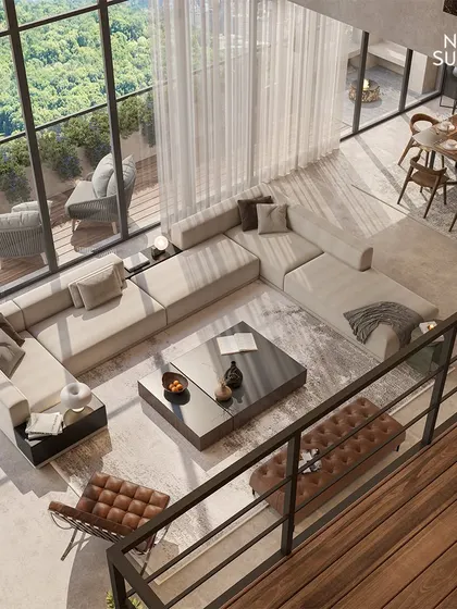 An aerial perspective of the open-plan living and dining area. This view emphasizes the spaciousness and flow we achieved, with a large sectional sofa anchoring the room and floor-to-ceiling windows connecting the interior to the lush green landscape outside.