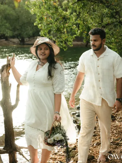 A sun-kissed walk along the riverbank. This pre-wedding photo captures a candid, romantic moment, using natural light to create a warm and gentle atmosphere.