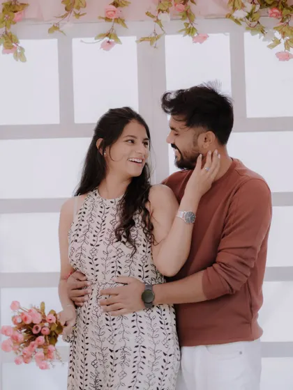 A tender moment against a romantic floral backdrop. The soft pink tones and the couple's gentle embrace create a dreamy and affectionate pre-wedding portrait.