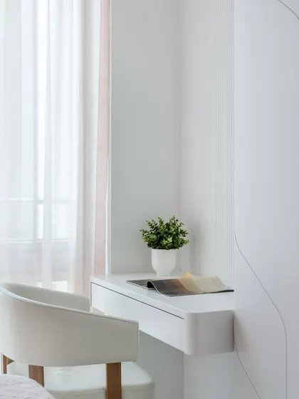 The compact and minimalist study area in the pink ombré bedroom, featuring a floating desk and chair, perfectly integrated into the room's design.