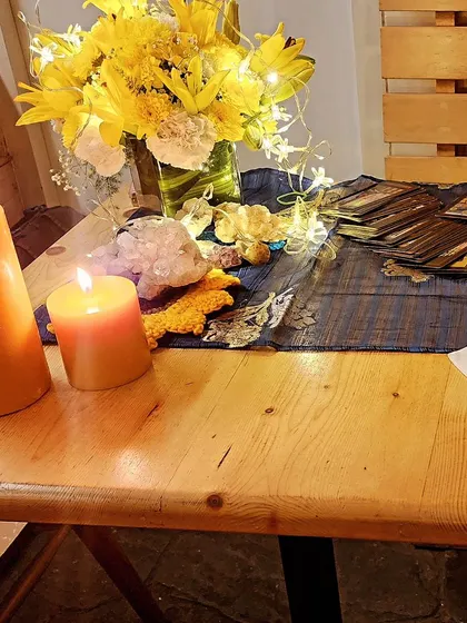 The ambiance of a tarot reading session is key. Here, warm candlelight, crystals, and flowers create a serene and magical atmosphere for a Bumble India event.