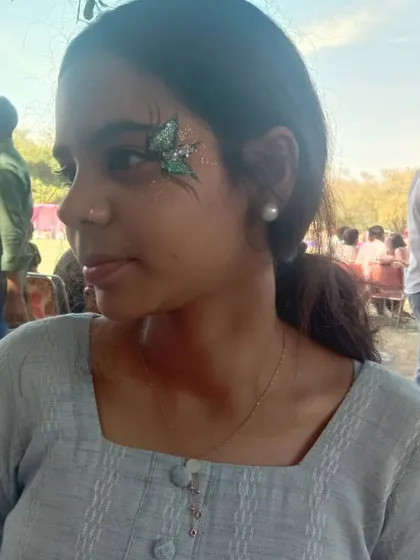 A small, green glitter butterfly perched by the eye. This is a great option if you want a subtle touch of art that still makes an impact.