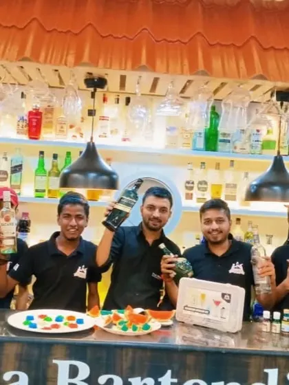 The team after a molecular mixology class, proudly holding up the spirits and ingredients they used to craft their drinks.