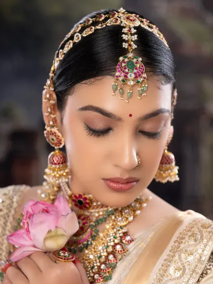 A detailed shot of the eye makeup and traditional hair accessories. Every element is carefully chosen to create a harmonious and beautiful bridal look.
