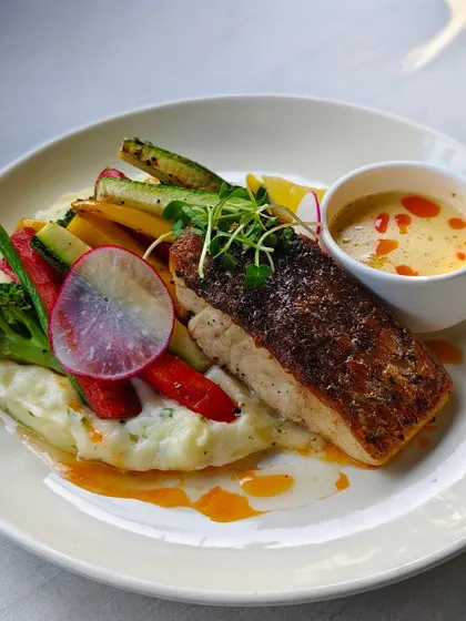 Pan-seared fish with a crispy skin, served on a bed of mashed potatoes with roasted vegetables and a light, flavorful sauce. It's one of my best-kept secrets.