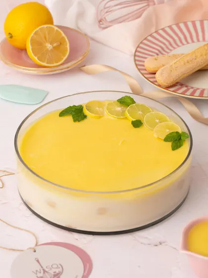 The full Lemon Tiramisu, garnished with fresh lemon slices and mint. It's a bright and zesty dessert, perfect for a sunny day.