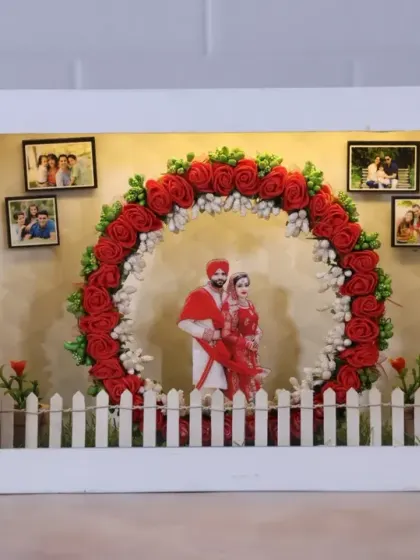 Our miniature theme box is a house in itself. This wedding-themed box features a couple's cutout, their photos on the wall, and a beautiful floral arch, all lit up with LEDs.