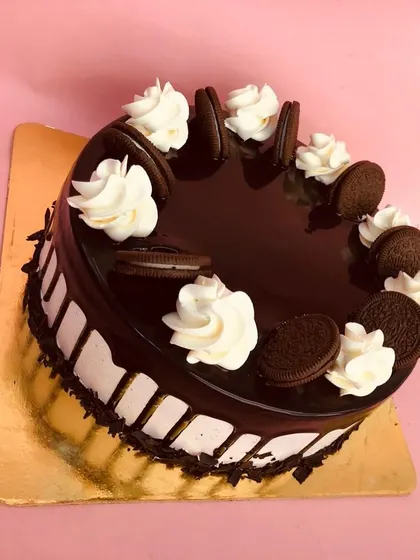 Our eggless Oreo cake is perfect for cookie lovers. It's decorated with a glossy chocolate glaze, whipped cream swirls, and whole Oreo cookies.