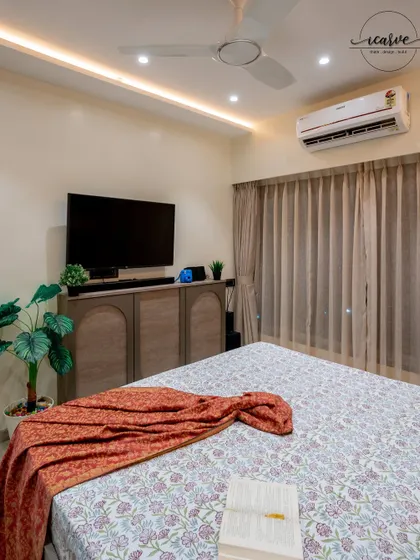 A clean and modern bedroom design with a custom TV console and warm lighting.