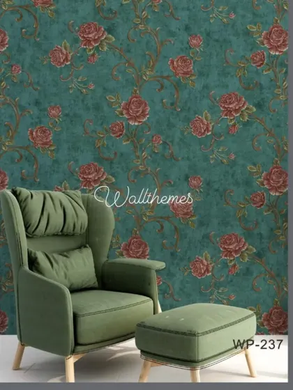 A bold floral wallpaper with red roses on a deep teal background, shown in a mockup with a modern green armchair.