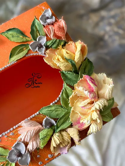 A close-up of the flowers on the orange tissue box, showing the soft, creamy texture of the petals.