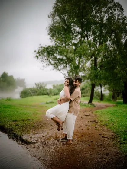 A playful lift in the rain-soaked earth. These are the unscripted, joyful moments that make a pre-wedding shoot so special, capturing pure, unfiltered happiness.