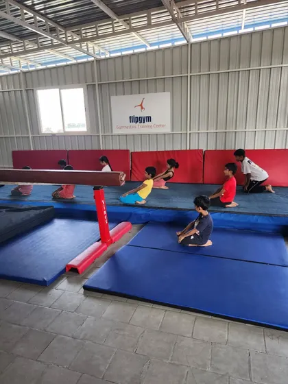 Our classes are structured to keep kids engaged. Here, students listen to instructions before practicing skills on the floor mats and balance beam.