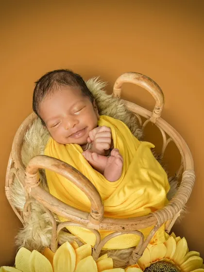 A sleepy smile from a newborn is pure gold. This little one, wrapped in sunny yellow and surrounded by sunflowers, shows how I combine color and props to create a cheerful yet peaceful atmosphere for your baby's first portraits.