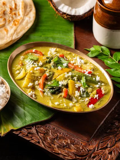 A different angle of a vegetable curry, showing the vibrant colors and fresh coconut garnish.