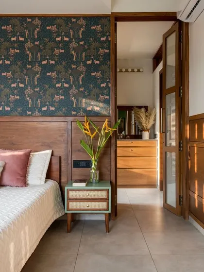 The primary bedroom in our penthouse features a stunning Sabyasachi wallpaper and custom wooden screen doors that play with light and privacy.