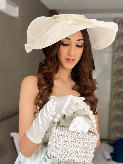 A stunning Bridgerton-themed look for a high tea party. The makeup is soft and skin-like, with a classic winged liner and soft curls for a vintage, romantic feel.