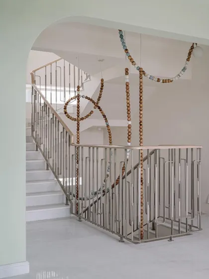 The clean lines of the staircase and railing at Eden House provide the perfect canvas for the organic, flowing form of the LUNA light installation. It's a beautiful example of balance in design.