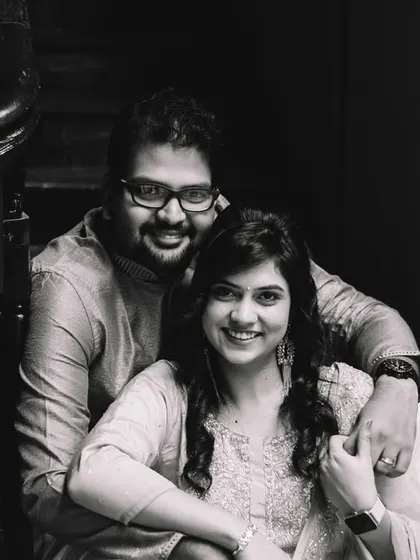 A classic black and white portrait of the couple on the stairs of the old wada. Their smiles are warm and genuine.