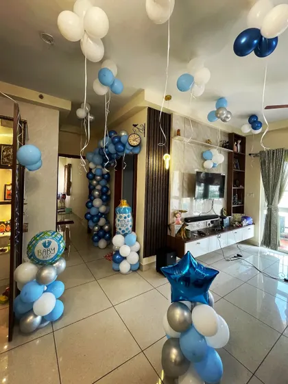 Even a small space can be transformed for a beautiful celebration. Here is an intimate 'Welcome Home' decoration for a baby boy, using balloon pillars, ceiling balloons, and themed banners to make the moment special.