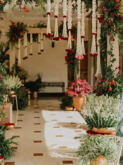 A beautiful floral entrance for a Mamera ceremony, using a vibrant palette of reds and oranges. The decor creates a warm and welcoming atmosphere for this important family ritual.