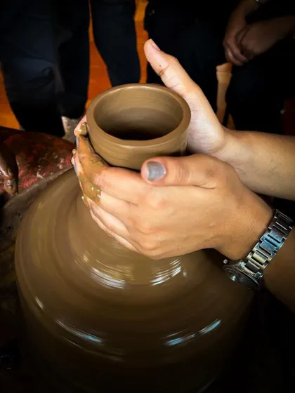 A guest focuses on shaping the rim of their creation. The concentration required for pottery makes it a wonderfully mindful and relaxing activity.