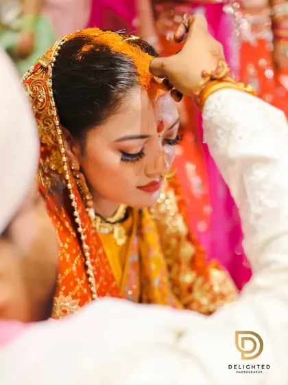 A close-up of the sindoor daan ceremony, a deeply significant and emotional moment in a Hindu wedding, captured with a focus on the bride's serene expression.