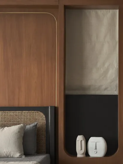 This detail shows the built-in niche next to the bed, a clever use of space that adds character and a place for personal decor. The wood panelling continues the room's warm, enveloping feel.