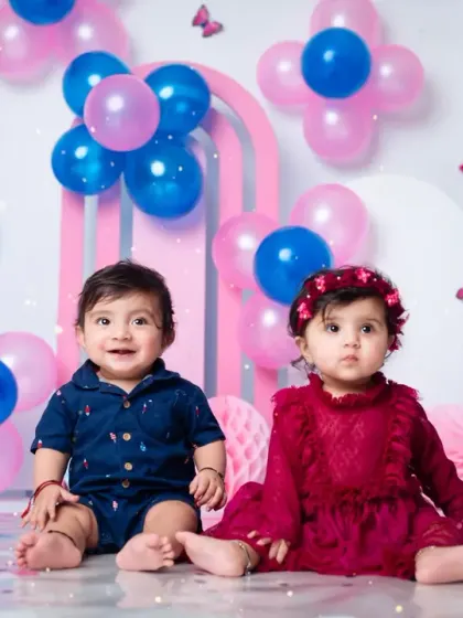 Two-of-a-kind! A delightful shot of twin siblings sitting together during their colorful first birthday session.