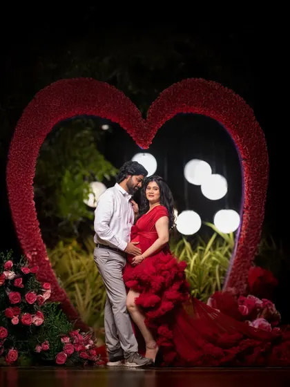 A dramatic night-time portrait using a large heart-shaped prop. The lighting creates a bold and glamorous look, perfect for couples who want a touch of drama.