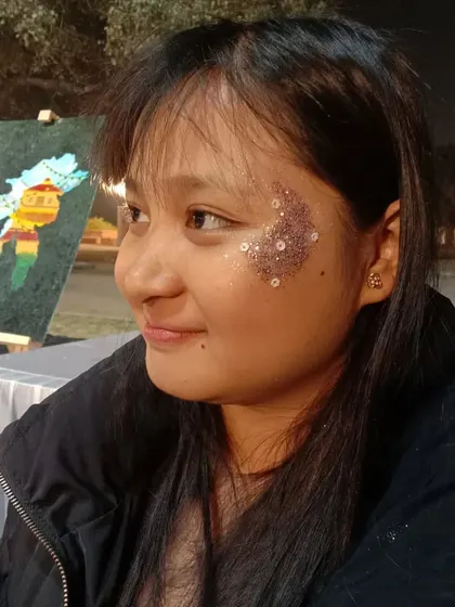 A soft application of pink and gold glitter on the cheek. This is a great way to add a subtle glow to your look.