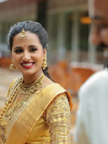 An over-the-shoulder shot capturing a sweet glance between the couple. The bride's profile shows off the clean lines of her makeup and her radiant skin.