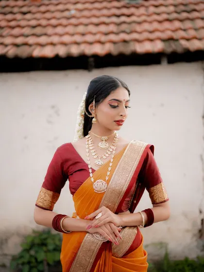 A classic portrait pose. The bride's hands are gently clasped, and her expression is calm and composed, radiating traditional elegance.